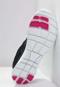 Czarny bieżnik obuwia sportowego z białą podeszwą środkową w różowe akcenty i teksturowaną powierzchnią zapewniającą przyczepność. Ustrukturyzowany wzór na całej powierzchni.