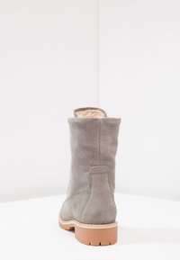 Stivale in suede grigio con una morbida fodera interna, altezza al polpaccio, dettagli cuciti e suola in gomma per trazione.