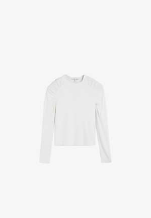 Haut blanc à manches longues avec texture côtelée, décolleté rond et détails froncés aux épaules, présentant une silhouette ajustée.