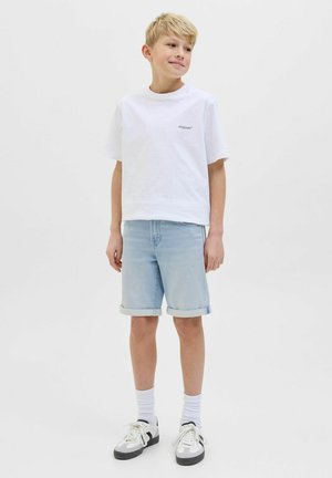 T-shirt bianca in cotone con logo "Originals", pantaloni corti in denim azzurro con risvolti, calze bianche e sneakers bianco e nere.