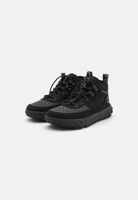 Zapatillas de senderismo de media caña negras, fabricadas en malla y gamuza, con secciones perforadas, suela de goma resistente y un diseño de cordones duradero.