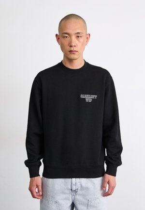 Black sweatshirt made of cotton blend, featuring ribbed cuffs and hem, with a small white "Carhartt WIP" logo on the chest.