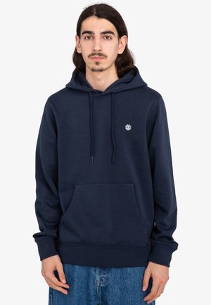 Sudadera azul marino de tela suave, con un bolsillo tipo canguro y capucha ajustable con cordón. Pequeño detalle del logo en el pecho.
