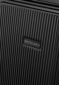 Valise rigide noire avec des stries texturées. Elle possède une étiquette rectangulaire avec "WITTCHEN" en argent à l'avant. Conception durable et légère.