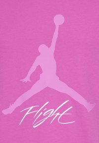 Różowa bawełniana koszulka z dużym, białym sylwetkowym logiem jumpmana oraz słowem "Flight" napisanym białą czcionką poniżej logo.