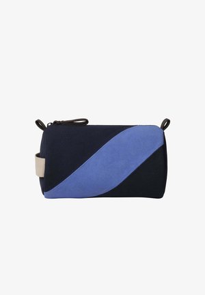 Blue and navy cosmetic bag with a curved design, made of fabric, featuring a beige strap and a zip closure, with a smooth texture.