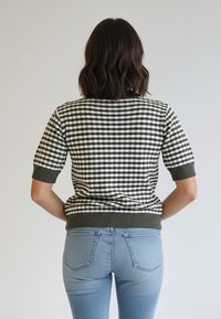 Krótki sweter z dzianiny o zielono-białym wzorze w kratę, z prążkowanym dołem i mankietami, o dopasowanym kroju.