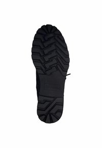 Semelle de chaussure en caoutchouc noir avec un motif de pilotis texturé composé de motifs en zigzag et de rainures horizontales, présentant une impression de logo.