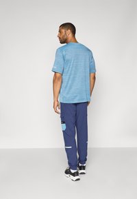 Under Armour UTILITY PANT - Tracksuit bottoms - washed navy/blue smoke/black
