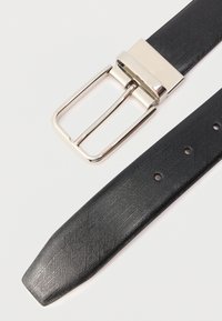 Črn usnjen pas z teksturo in srebrno kovinsko sponko, ki ima klasičen dizajn ter več rež za prilagoditev dolžine na pasu.