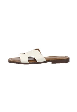 Sandalias planas de cuero blanco con dos correas cruzadas y una suela de goma marrón, que presentan una textura suave y un diseño minimalista.