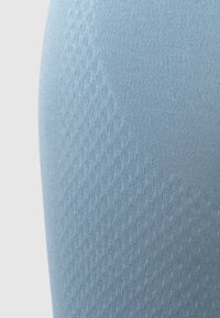 Tessuto in blu chiaro con texture che presenta un sottile motivo geometrico e una superficie liscia e elastica. Ideale per applicazioni di abbigliamento sportivo.