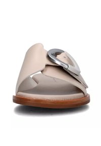 Infradito in pelle beige con una fascia superiore ampia e hardware circolare in argento, caratterizzate da una punta aperta e una soletta in legno marrone.