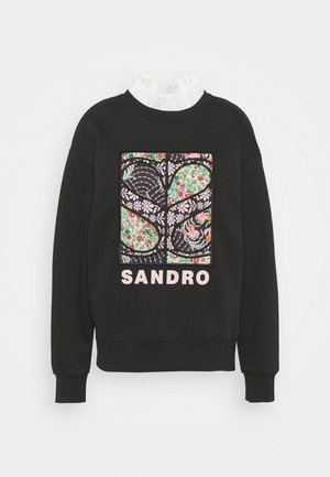Zwarte sweater met meerkleurig bloemmotief en "SANDRO" tekst aan de voorkant, gecombineerd met een witte gerimpelde col eronder.