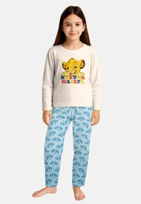 Maglietta da pigiama a manica lunga di colore crema con la scritta "Hakuna Matata" e una grafica di Simba. Pantaloni da pigiama blu con motivo di Simba azzurro chiaro. Tessuto di cotone.