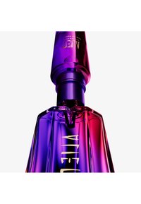 Nahaufnahme einer violett-pinken Glas-Parfümflasche mit passendem Sprühkopf und goldenen Schriftzügen.