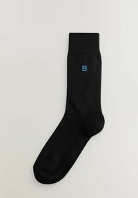 Sort sok lavet af et glat stof med en ribbet manchet og et lille blåt logo på siden. Standardskabelon og design til afslappet brug.
