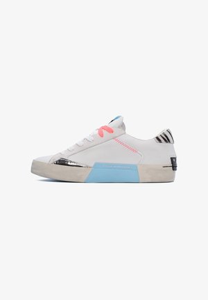 Sneakers bianchi con tomaia in pelle liscia, dotati di lacci rosa, accenti argentati e suola in gomma blu. Dettagli testurizzati in bianco e nero sul tallone.