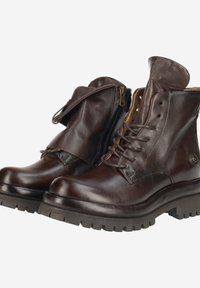 Bottines en cuir marron avec un laçage à l'avant et une fermeture éclair sur le côté. Semelle robuste et design à rabat plié. Texture lisse avec des accents minimaux.