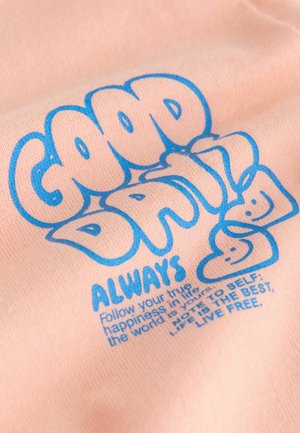 Brzoskwiniowy materiał z niebieskim, graficznym napisem "GOOD DRIL" i "ALWAYS" w zabawnym stylu, z uśmiechniętymi twarzami i motywacyjnymi hasłami.