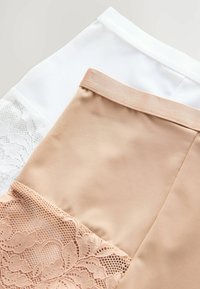 Beige en witte kledingstukken met kantaccenten. De witte stof heeft een kantsectie, terwijl de beige stof een gladde textuur heeft.