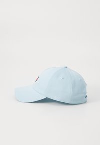 Lyseblå baseballcap lavet af stof, med en buet skygge, justerbar bag og lille broderet logo foran.