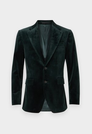 Dark green velvet blazer with peak lapels, two buttons, and two front pockets. Smooth texture, tailored fit, and single back vent.