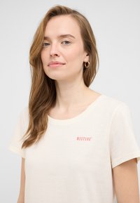 Kremkrāsas T-krekls mīkstā audumā, ar īsām piedurknēm un apaļu kakla izgriezumu. Uz krūškurvja izdrukāts sarkans "MUSTANG" logo.