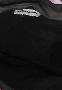 Interior negro de una bolsa con una etiqueta etiquetada como "Blauer". El material parece suave, sin patrones visibles ni detalles de hardware.