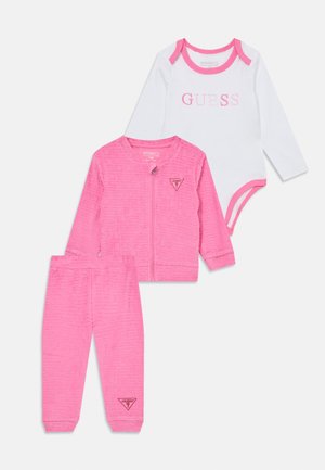 Tre-delt børnetøjssæt bestående af en hvid langærmet bodysuit med pink kant, en pink jakke med lynlås og matchende bukser med et struktureret mønster.