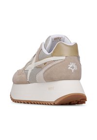 Sneaker beige in suede e mesh con dettagli bianchi e dorati, una spessa intersuola bianca e una suola in gomma testurizzata con pattern di trazione.