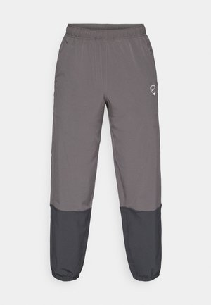 Grijze sportbroek met elastische tailleband, twee zijzakken en zwarte onderpanelen. Gemaakt van lichtgewicht materiaal, met een logo-accent.
