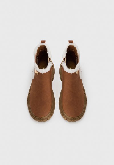 Botas acastanhadas de tornozelo com um suave acabamento em pele de pelo branco, fechos laterais e solas de borracha texturizada. Material liso semelhante ao couro e design de bico redondo.
