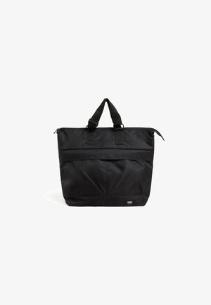 Czarna torba typu tote marki Vans z podwójnymi górnymi uchwytami, zamknięciem na zamek błyskawiczny oraz małą naszywką z logo blisko dołu na białym tle.
