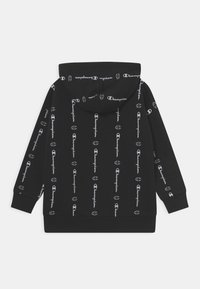 Svart huvtröja med vitt mönster av "Champion"-logotyp över hela plagget. Mjuk tyg med avslappnad passform och ribbade muddar och fåll.