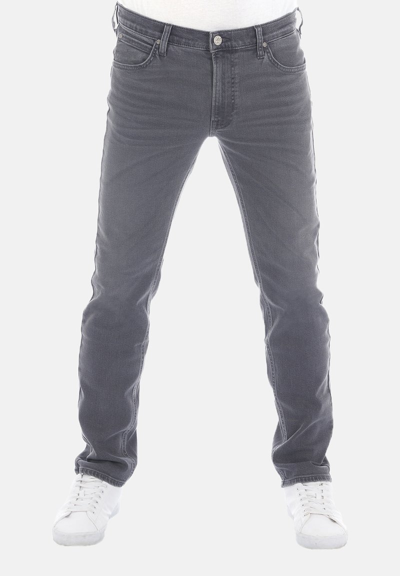 Grijze denim jeans met een slim fit, voorzien van vijf zakken, een bovenste knoopsluiting en witte sneakers. Geen zichtbare versieringen of patronen.