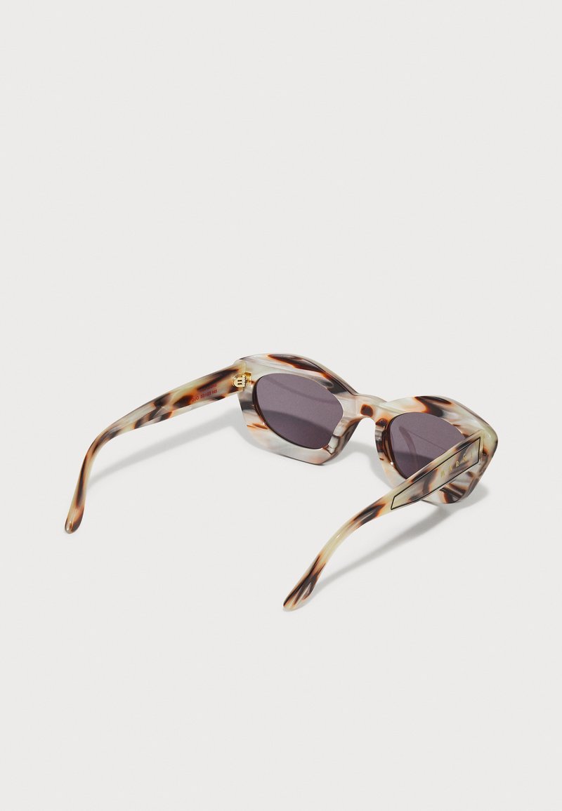 Lunettes de soleil en écaille de tortue avec des montures angulaires et des verres sombres. Présentent des branches fines et des accents matériels subtils. Matériau en plastique léger.