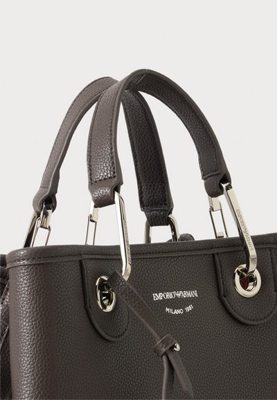 Σκούρα καφέ τσάντα Emporio Armani από δέρμα με υφή, με διπλές λαβές και ασημένια μεταλλικά εξαρτήματα, εμφανίζει το λογότυπο της μάρκας και το κείμενο Milano 1981.