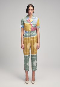 Mono colorido y estampado con mangas cortas, cintura elástica y piernas acortadas. Presenta diseños variados en verde, amarillo, rosa y azul.