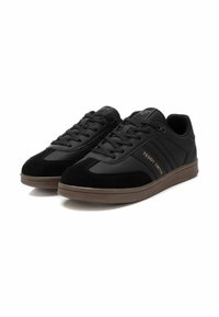 Sneakers neri realizzati in pelle liscia e camoscio; presentano cuciture decorative, chiusura con lacci e una suola in gomma marrone. Logo "TEDDY SMITH" visibile.