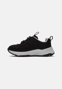 Chaussures de sport noires avec un dessus en maille, des accents renforcés et une semelle intermédiaire blanche. Dotées de sangles ajustables pour un maintien sécurisé et d'une semelle extérieure texturée.