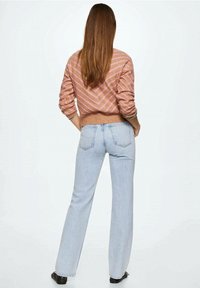 Jeans de talle alto azul claro con corte de pierna recta, combinados con un suéter a rayas rosas y marrones, con una cintura acanalada.