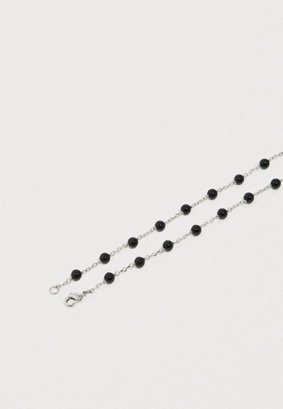 Colier cu mărgele negre, format din două șiruri, legate cu un lanț metalic de culoare argintie, încheiat cu o închizătoare.