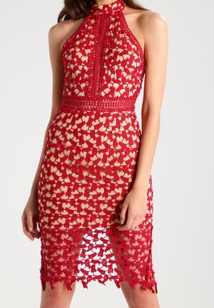 Robe rouge en dentelle avec col halter, doublure couleur chair, silhouette ajustée, et motif floral découpé complexe s'étendant sous le genou.