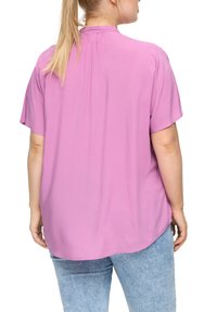 Korte mouwen, roze blouse met een vloeiende ontwerp, een lichte high-low zoom en een rugplooidetail, gemaakt van lichtgewicht stof.
