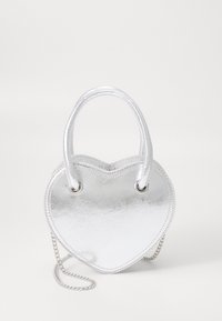 Stříbrná kabelka ve tvaru srdce s hladkým kovovým povrchem, dvojitými uchy a odnímatelným řetízkem. Minimalistický design bez vzorů.