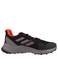 Chaussure de sport noire avec des accents gris, tige en mesh texturé, semelle rembourrée et reflets intérieurs orange vif, dotée d'un profil de semelle robuste.