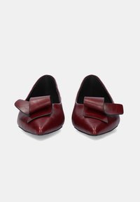 Bailarinas de cuero burdeos con punta afilada y un gran lazo en el lateral. Textura suave con interior negro contrastante.
