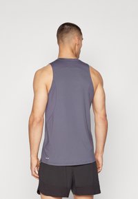 Grå ærmeløs atletisk tanktop lavet af letvægtsstof, med rund halsudskæring og en afslappet pasform, synlige sømme og et lille logo.