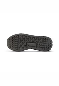 Suela de goma negra con una superficie texturizada y con patrón. Logo de Puma prominente en el centro. Presenta patrones de agarre circulares y cuadrados para mayor tracción.
